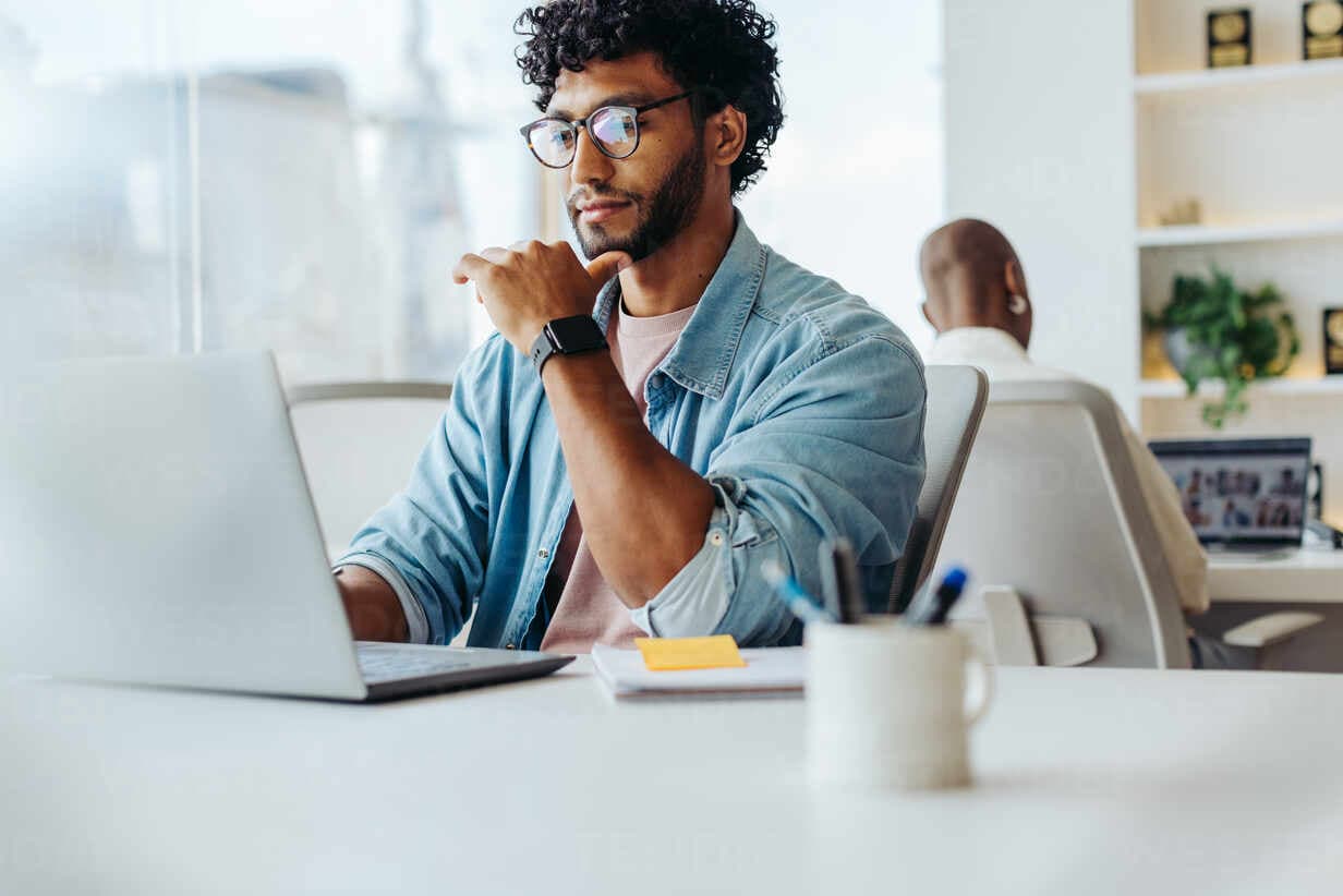 A focused professional reviewing his learning progress at a laptop